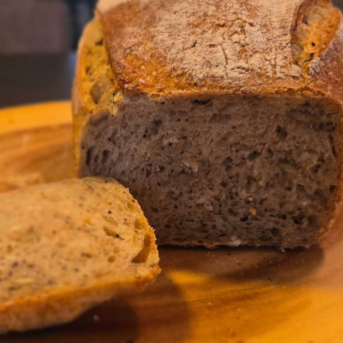 Loaf of bread with a slice cut, on a wooden surface