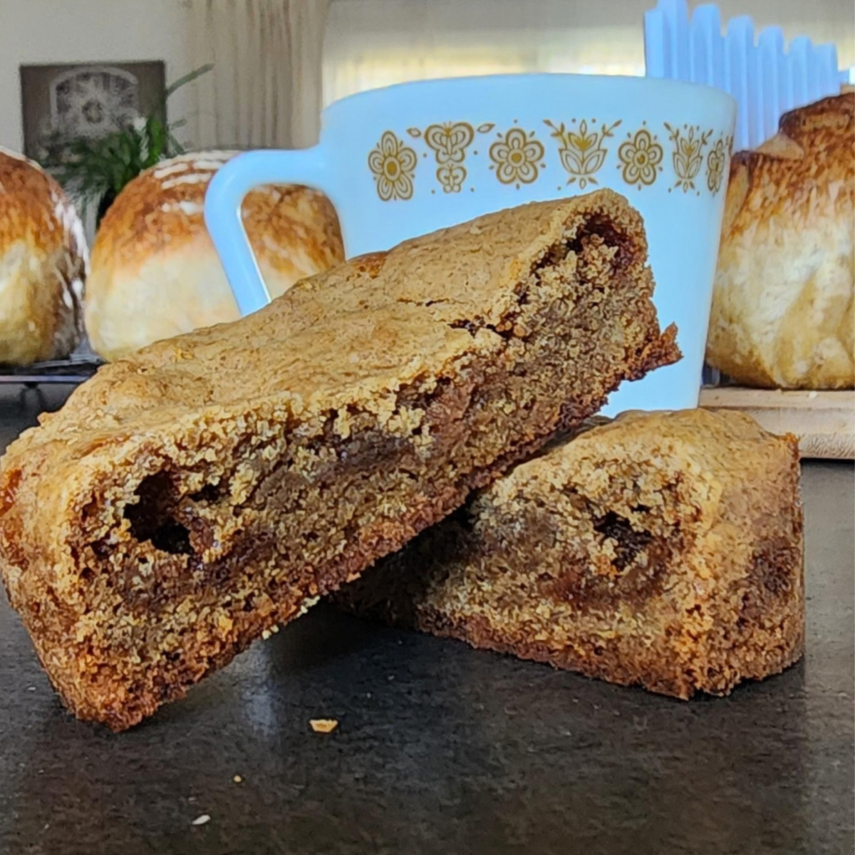 cookie on counter with coffee mug behind it